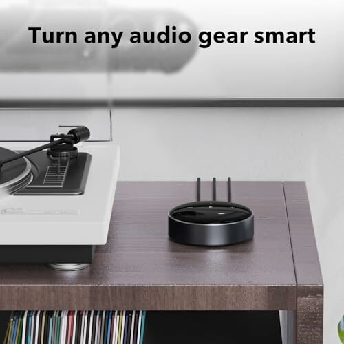 Smart audio adapter beside a turntable on a wooden table.