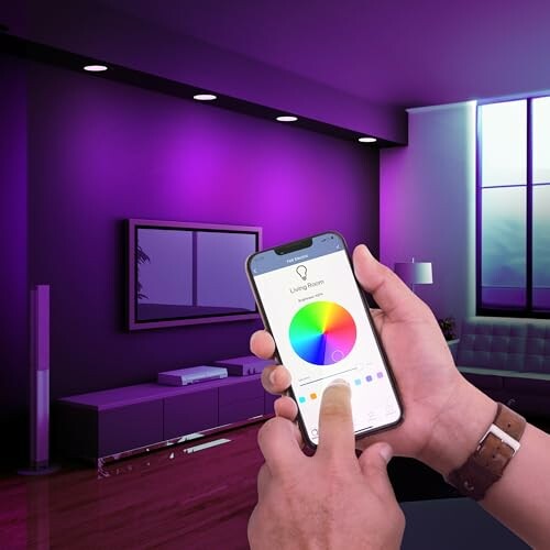 Person using smartphone app to control purple room lighting.