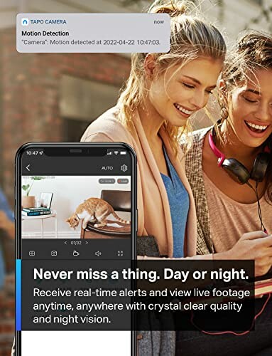 Women viewing security camera app on phone, receiving motion detection alert.